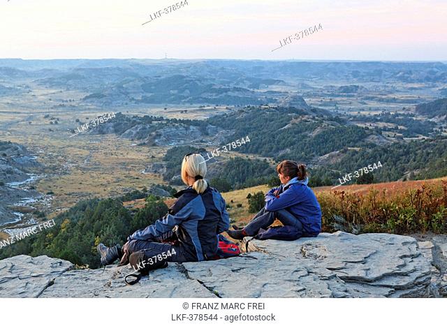 Two women sitting on the rocks, Theodore Roosevelt National Park, Medora, North Dakota, USA