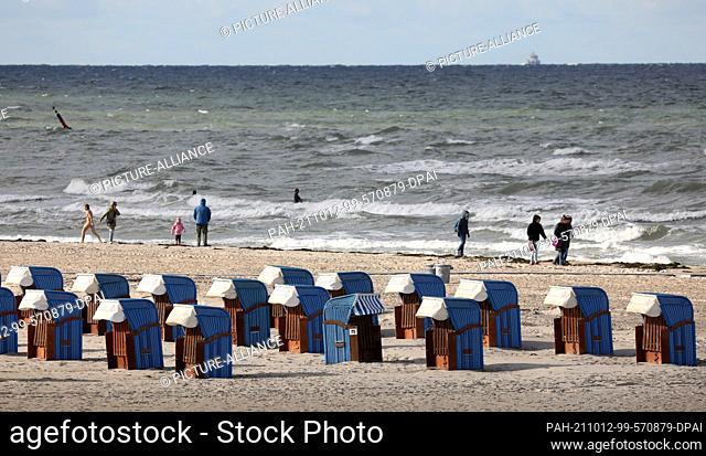 12 October 2021, Mecklenburg-Western Pomerania, Warnemünde: There are still many beach chairs on the Baltic Sea beach, they are now allowed to stay until the...