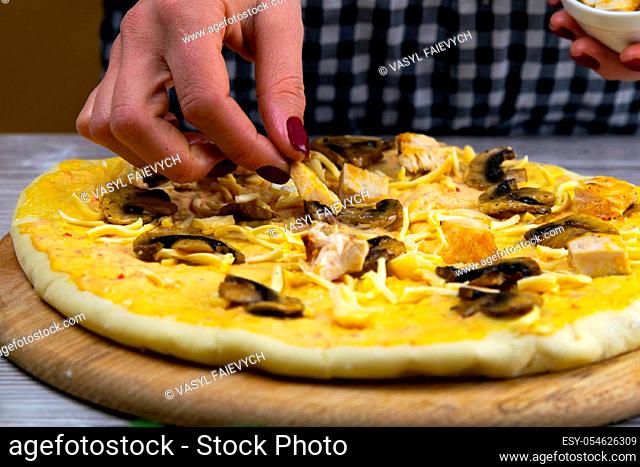 Woman tossing a slice of pizza dough. Fresh original italian raw pizza. Preparatory process
