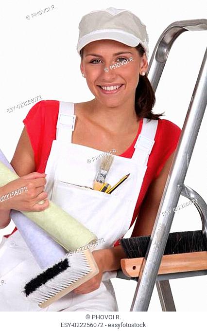 Female decorator with wallpaper
