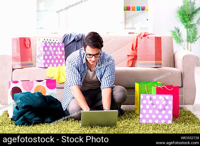 Young man buying clothing online and running blog
