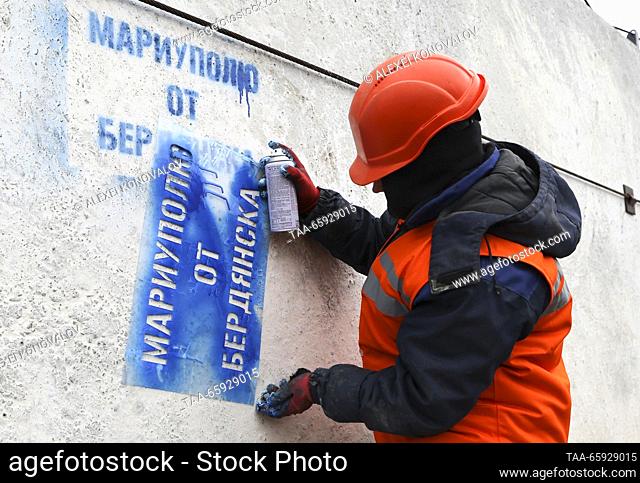 RUSSIA, ZAPOROZHYE REGION - DECEMBER 19, 2023: An employee applies a sign reading ""From Berdyansk To Mariupol"" onto a reinforced concrete structure at a plant...