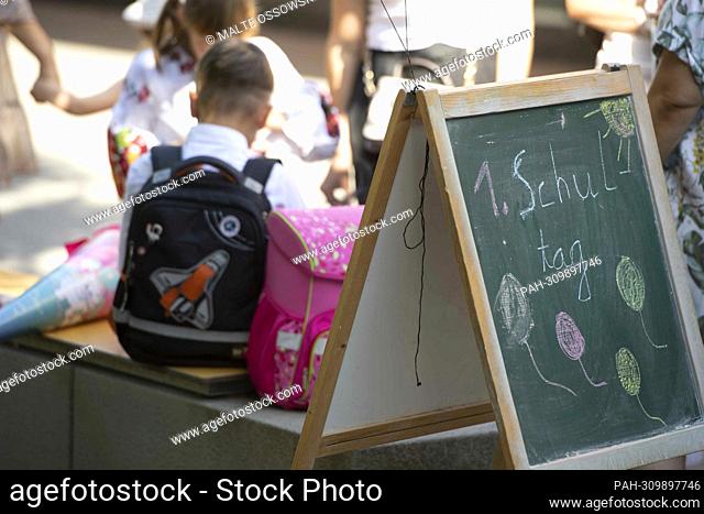 , ,1. Schultag, , is written on a blackboard, in the schoolyard of the Anne Frank Elementary School, children and parents are waiting to be admitted