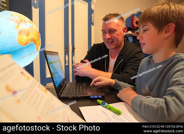 ILLUSTRATION - 16 January 2021, Bavaria, Neustadt Bei Coburg: A boy uses a laptop with his father for homeschooling. Photo: Nicolas Armer/dpa