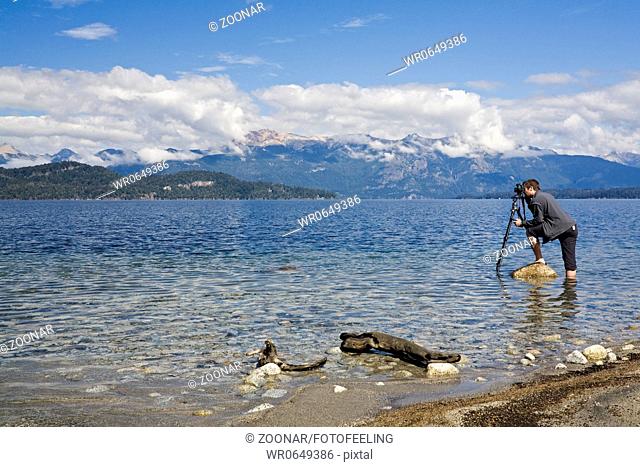 Fotograf steht im See Nahuel Huapi, Argentinien, phographer stands in the lake Nahuel Huapi, Argentina