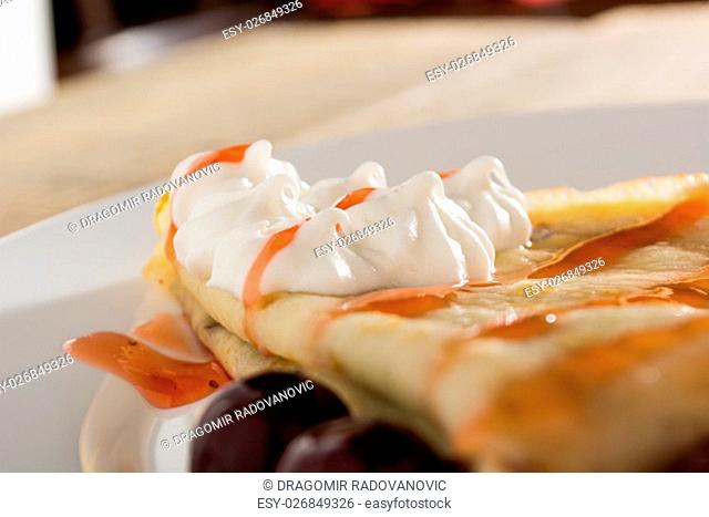 Fresh pancakes with cherry arranged on wooden table