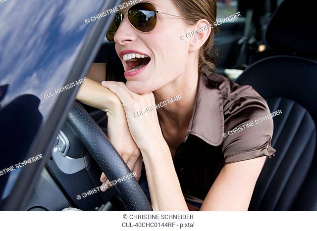 Smiling woman wearing sunglasses in car