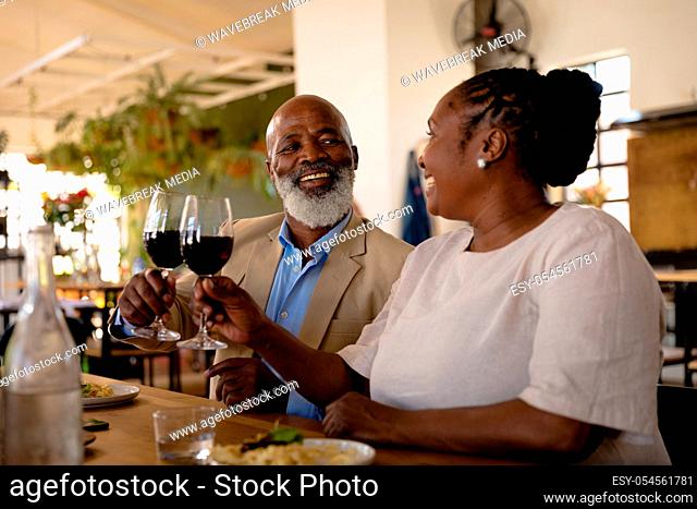 Side view of an Senior African man and an African woman at cookery class, making a toast. Active Seniors enjoying their retirement