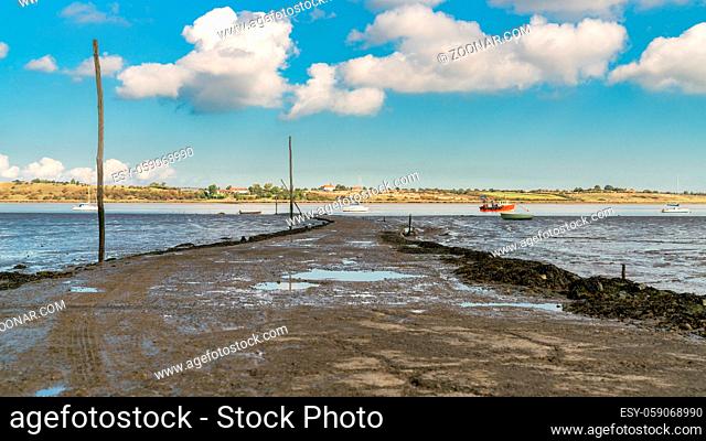 Boats in the Oare Marshes with the Isle of Sheppey in the background, near Faversham, Kent, England, UK