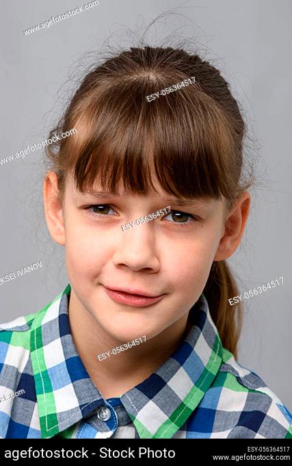 Portrait of embarrassed ten-year-old girl, European appearance, close-up