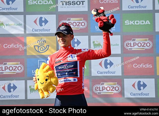 Belgian Remco Evenepoel of Quick-Step Alpha Vinyl celebrates on the podium in the red jersey for leader in the overall ranking after stage 9 of the 2022 edition...