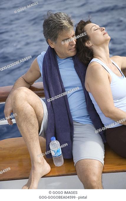 Couple resting on ship’s deck