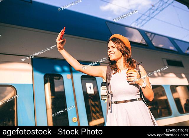 Cheerful woman traveler with backpack taking photo. selfie in train station. Travel lifestyle concept. woman shoot photo of yourself