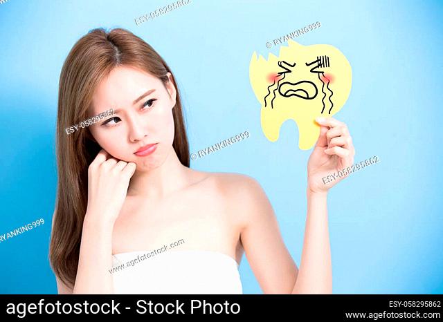 woman take decay tooth billboard and feel angry on the blue background