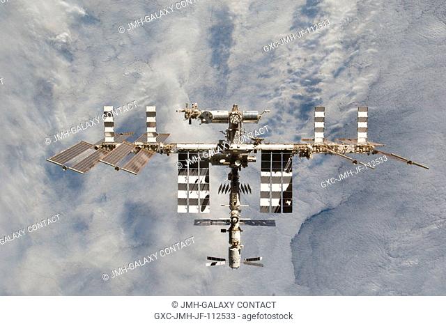 The International Space Station is featured in this image photographed by an STS-133 crew member on space shuttle Discovery after the station and shuttle began...