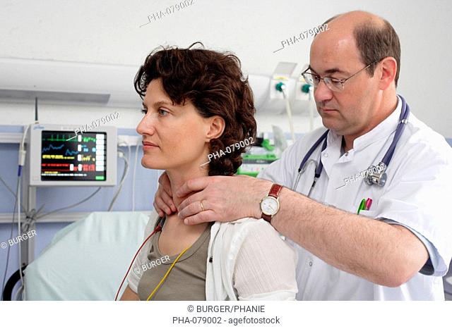 Hospital doctor examining the thyroid gland of a patient at emergency department