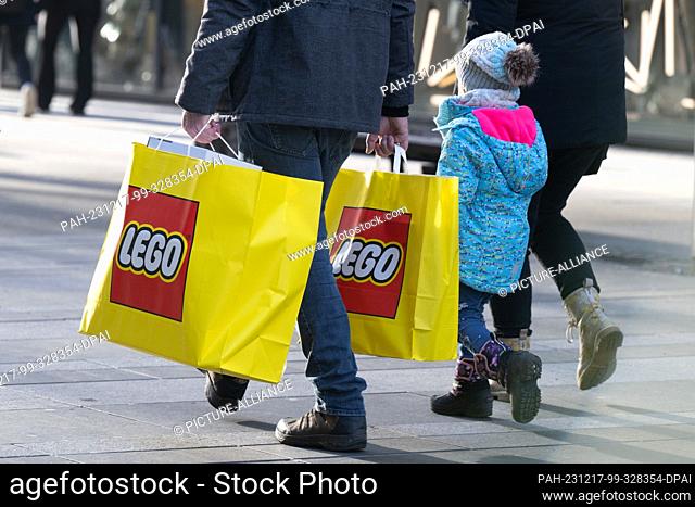 17 December 2023, Saxony, Dresden: Passers-by walk along a pedestrian zone with shopping bags during Sunday shopping. For the last time before Christmas this...