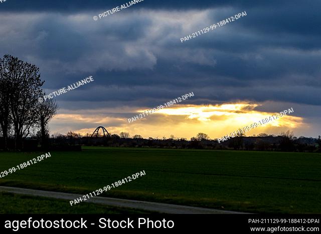 29 November 2021, Schleswig-Holstein, Ehlerstorf: The sun shines through dark clouds onto the Fehmarnsund Bridge. Photo: Frank Molter/dpa