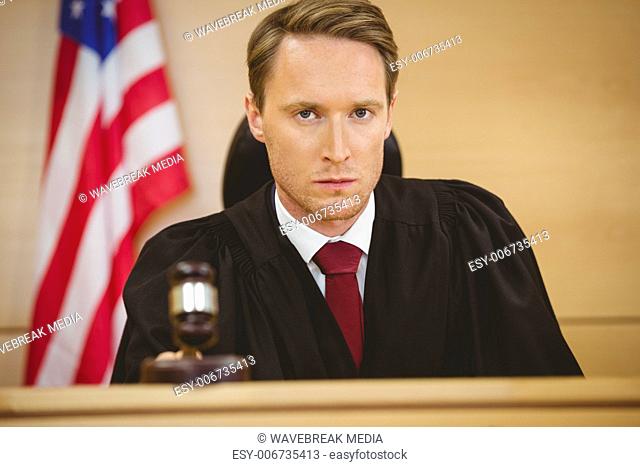 Portrait of a judge about to bang gavel on sounding block