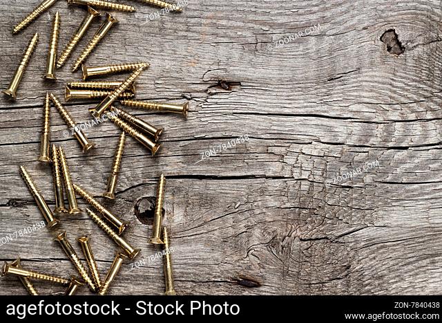 new yellow screws on the wooden table background
