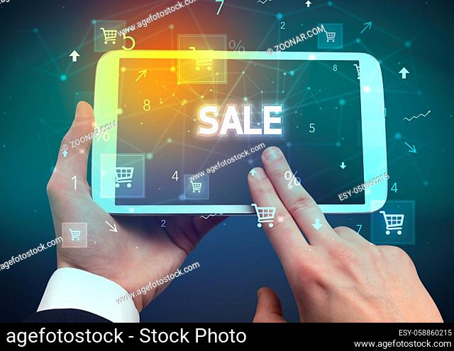 Close-up of a hand holding tablet with SALE inscription, online shopping concept