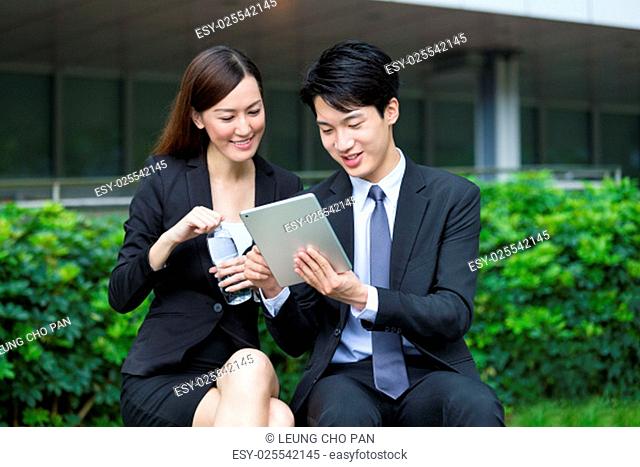Businesswoman reading something on digital tablet with businessman