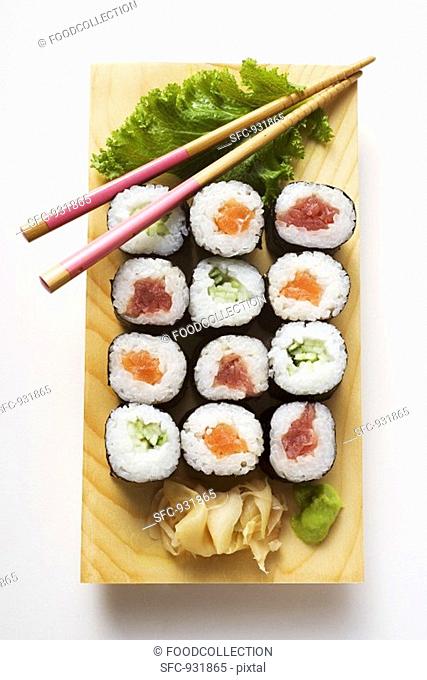 Maki sushi with fish and cucumber on sushi board
