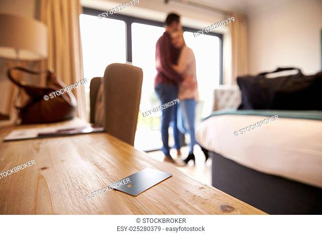 Hotel Room Key With Romantic Couple In Background