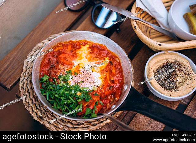 Shakshuka, Fried Eggs in Tomato Sauce on the Table. Street Restaurant