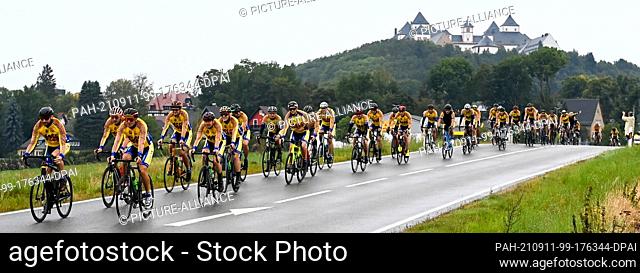 dpatop - 11 September 2021, Saxony, Augustusburg: Cyclists are on the road at the ""European Peace Ride"" in front of Augustusburg Castle