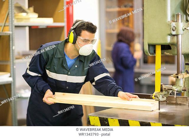 Craftsman wearing safety protection using saw