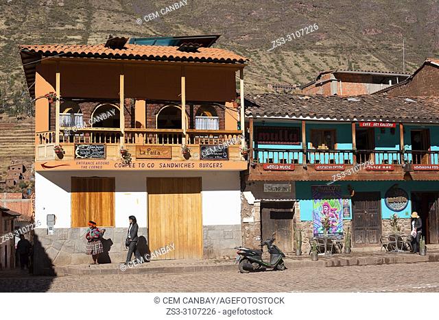 Local people in front of the colonial buildings used as restaurants at the town center, Pisac, Sacred Valley, Cusco Region, Peru, South America