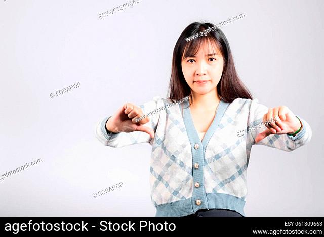 Unhappy woman smile show finger thumbs down rejection unlike, Portrait Asian beautiful young female negative gesture showing finger thumbs down or dislike sign...