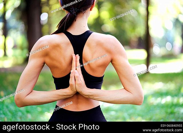Athletic young woman doing yoga in the Park in the morning, women's training on a yoga Mat