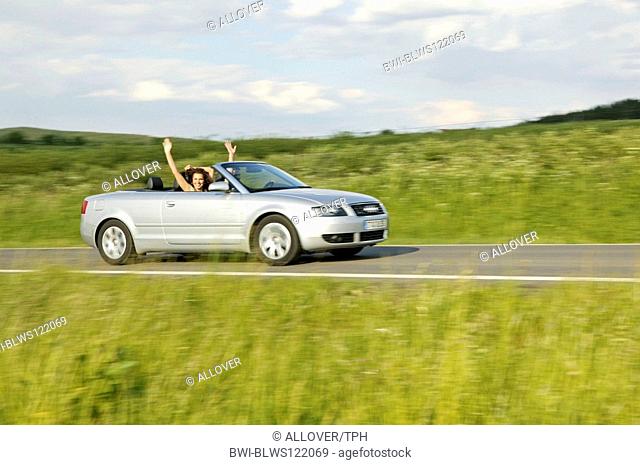 young couple driving with ragtop
