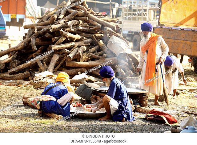 Nihangs or Sikh warrior preparing their meals near Sachkhand Saheb Gurudwara in Nanded ; Maharashtra ; India