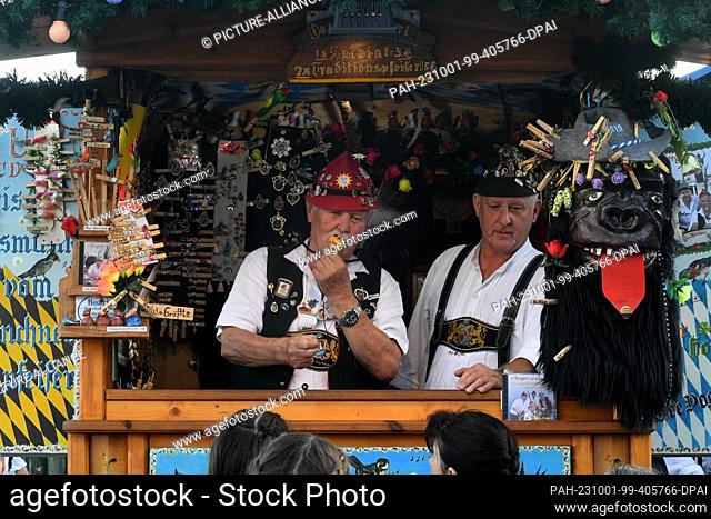 01 October 2023, Bavaria, Munich: The bird whistlers Horst (l) and Tobi Berger stand in their booth at the Oktoberfest. The 188th Wiesn takes place this year...