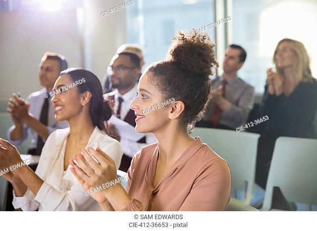 Businesswomen clapping in conference audience