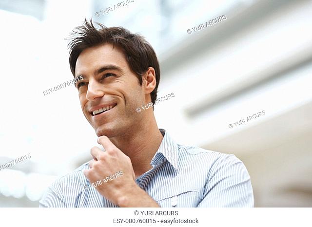 Closeup of a happy young business man looking away with copyspace