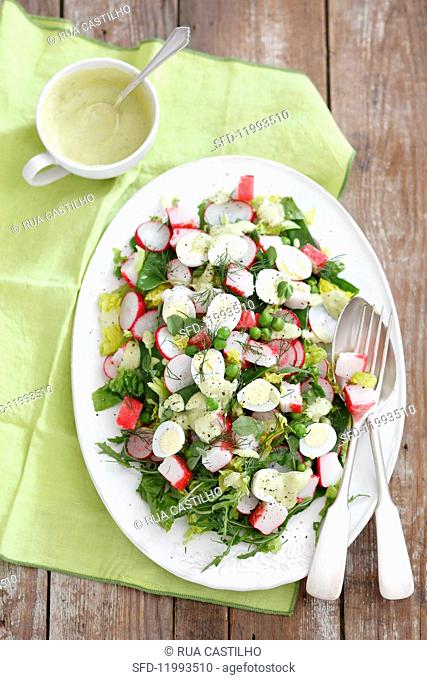 Salad with surimi, quail eggs, radishes, peas and mayonnaise dressing