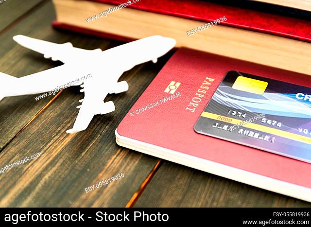 Credit card put on passport and airplane model on wooden table , Preparation for Traveling concept