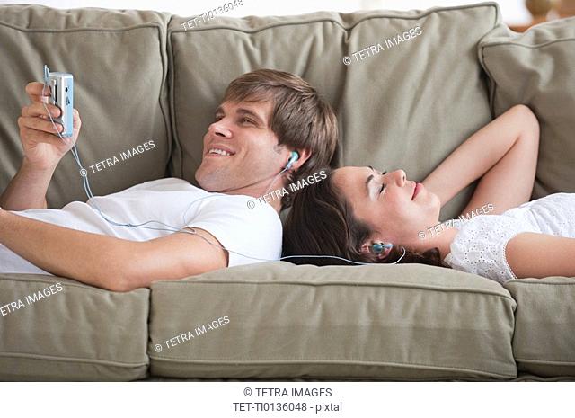 Couple in living room listening to music