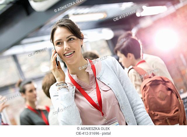Smiling businesswoman talking on cell phone at conference