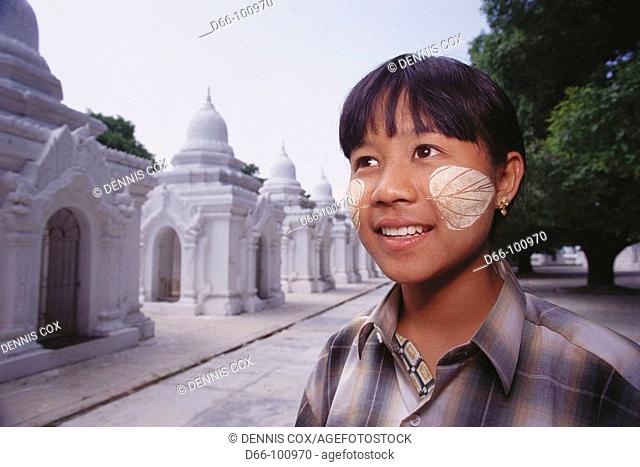Woman with thanaka bark make-up in leaf design, Kuthodaw Pagoda, Mandalay. Burma (Myanmar)