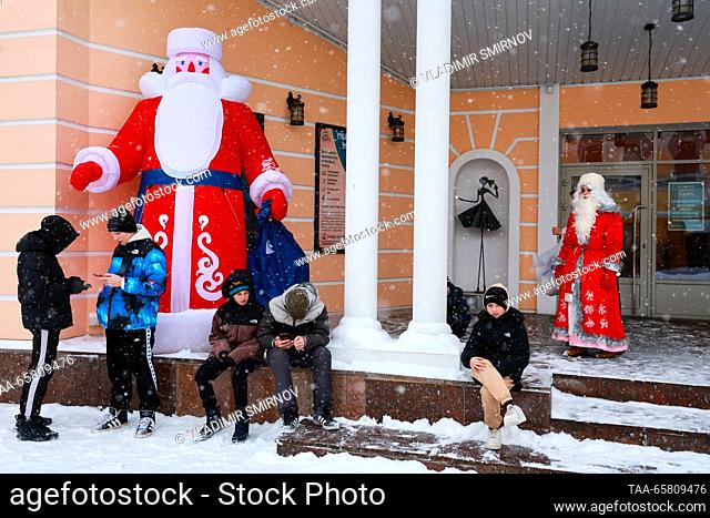 RUSSIA, RYBINSK - DECEMBER 16, 2023: Teenagers and a performer dressed in a Father Frost (Russian Santa Claus) costume is seen outside the Rybinsk Drama Theatre...