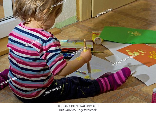 Little girl painting with acrylic paint, Germany, Europe