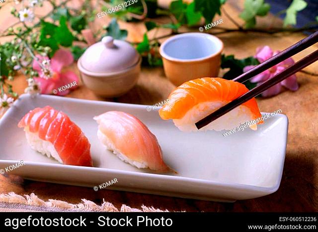 Sushi being eaten with chopsticks