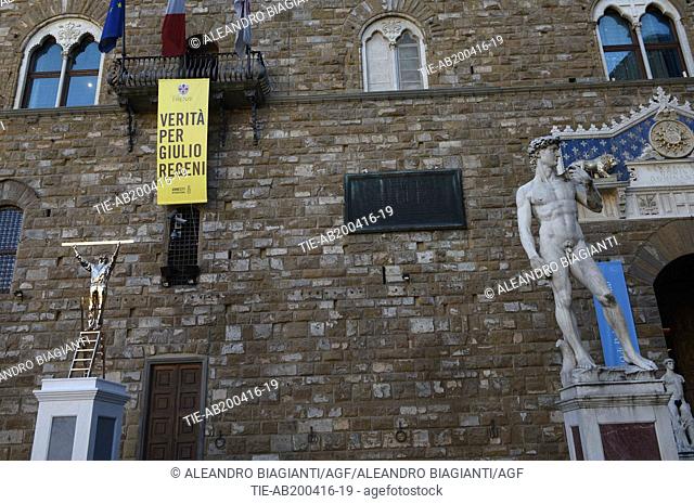 Banner 'Truth for Giulio Regeni' exposed on Palazzo Vecchio, under the banner the sculpture by Jan Fabre 'Man who measures the clouds', Florence