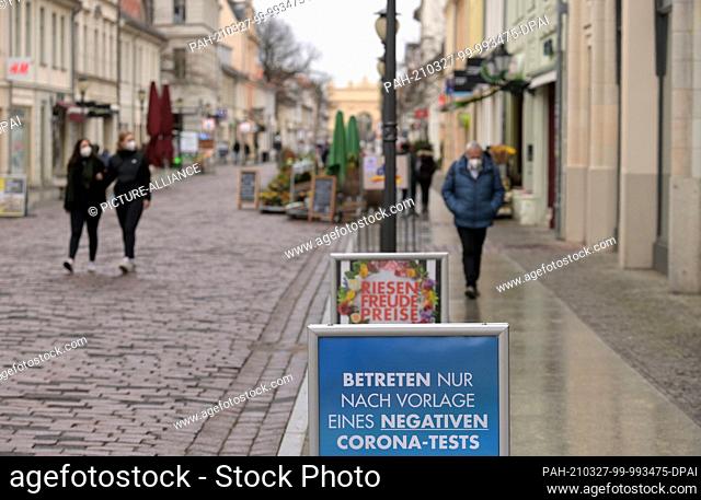 27 March 2021, Brandenburg, Potsdam: A sign with the inscription ""Enter only after presenting a negative Corona test"" stands in front of the Karstadt...