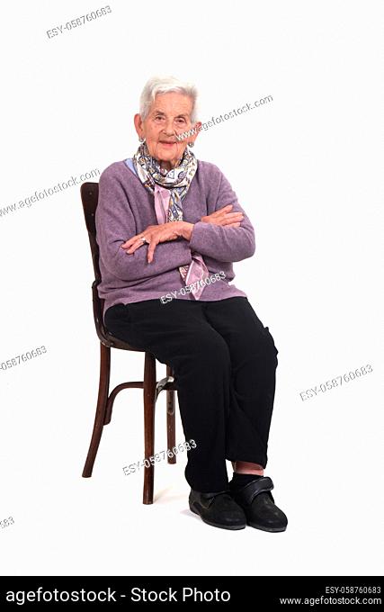 side view of senior woman sitting on chair arms crossed on whte background